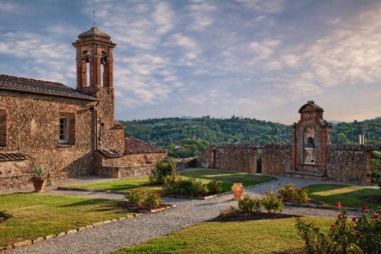 Vista del giardino del palazzo comunale e della Chiesa del Suffragio a Monte San Savino con colline toscane sullo sfondo